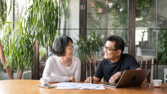 Two people sitting at a table and smiling as they look at each other